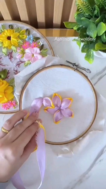 Ribbon Flower on a Hoop Tutorial via: @asnimar_embroideryCreate a charming ribbon flower on a hoop with this easy tutorial, perfect for adding a touch of elegance to your clothes or gifts.