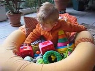 Simon assis dans sa piscine de jouets
