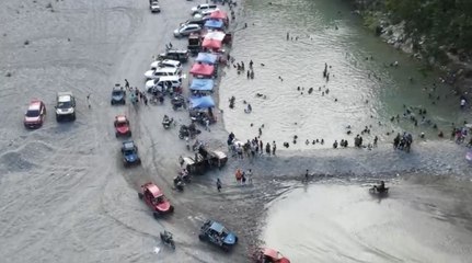 Personas en vehículos en balnearios cerca de la presa Valdesia