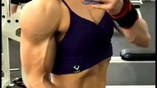 Buff female bodybuilder flexing after workout