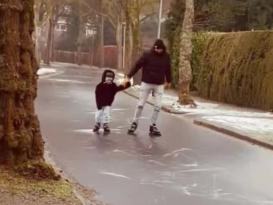 Wegen Glatteis: Menschen rodeln und fahren Schlittschuh auf der Straße