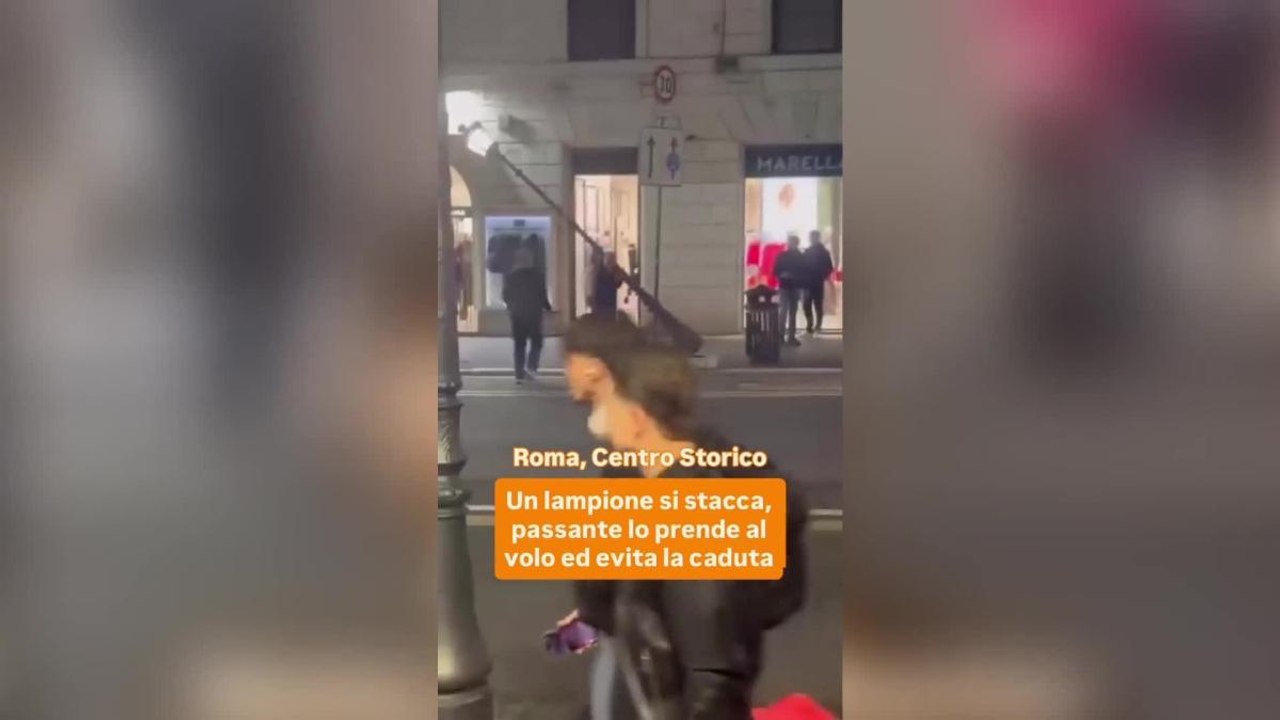 Via Nazionale, cade il palo della luce e un passante lo sorregge al volo