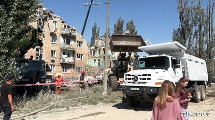I soccorritori coi sacchi per cadaveri dopo l'attacco russo a Kiev