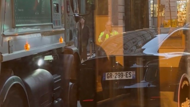 Garbage truck brushes against parked car while squeezing through a narrow street