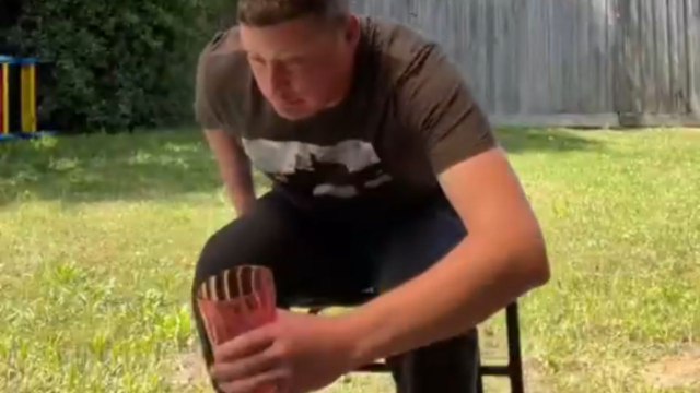 Man falls when the chair slips away as he tries to sit down
