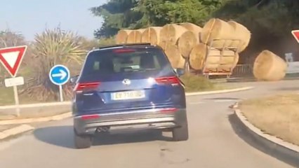 Tractor drops hay bale in roundabout and driver continues without noticing