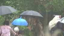 Sweet moment Kate shields schoolchildren during rain as she debuts blonde hair