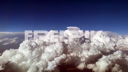 stunning pilot view from a jet cockpit avoiding stormy cumulus clouds in a messy and deep blue sky