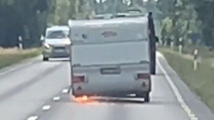 Camper loses wheel but persistent driver still keeps pushing it forward