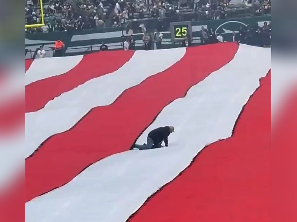 Bei Footballspiel: Mann krabbelt über riesige US-Flagge
