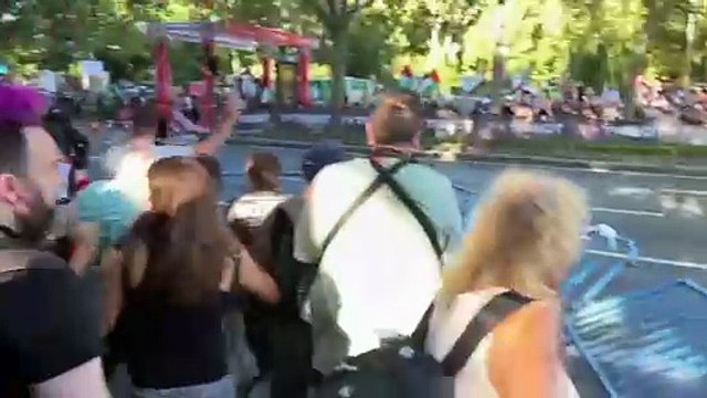 Momento en el que los manifestantes derriban la valla de seguridad de La Vuelta en Atocha