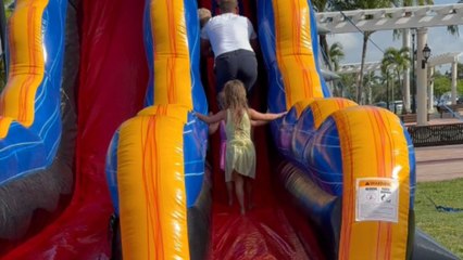 Dad slips while guiding his son on water slide and bumps into kids behind him