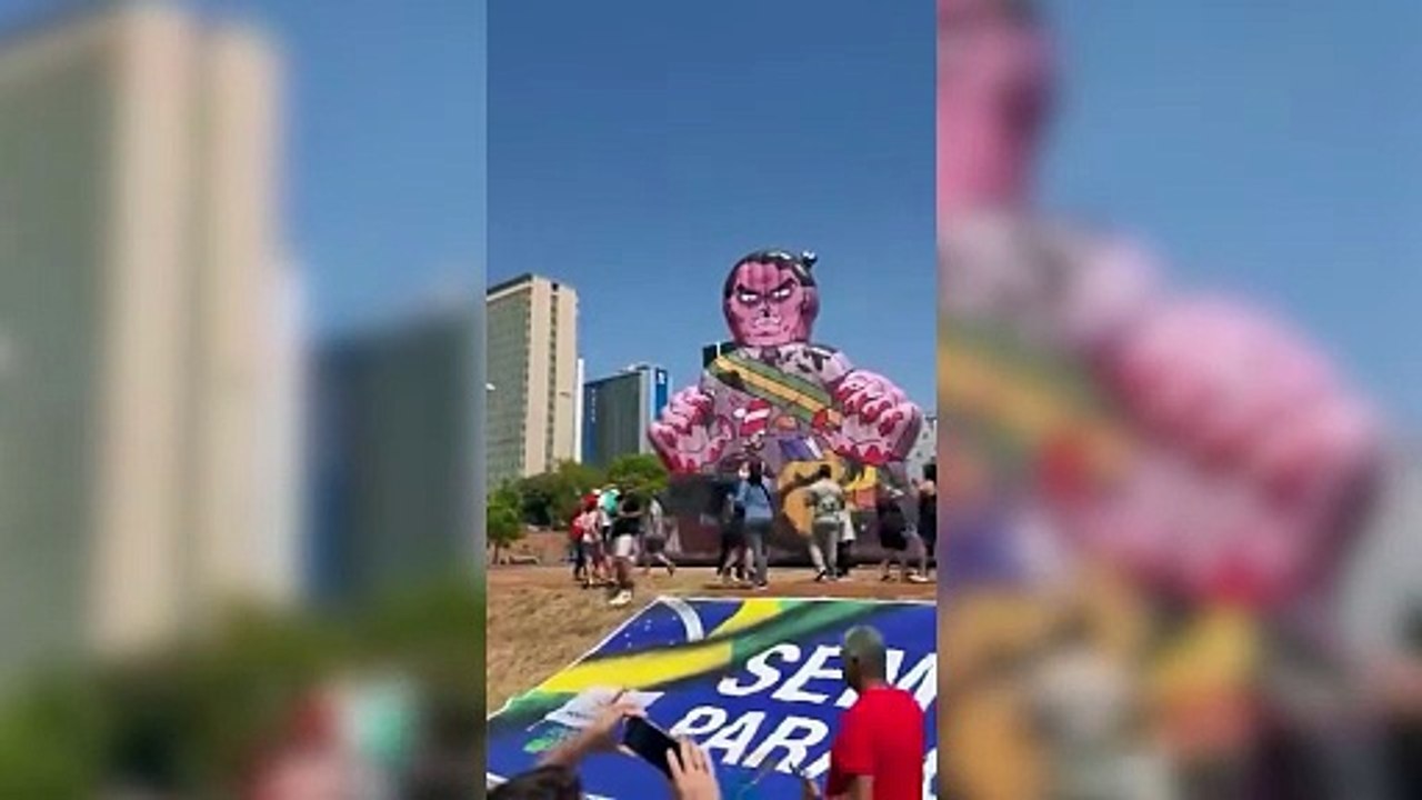 En Brasilia manifestantes suben a un muñeco inflable que representa al expresidente Jair Bolsonaro como un prisionero diabólico
