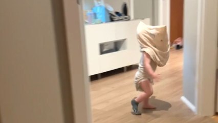 One-year-old walks around with a pillow cover stuck on face