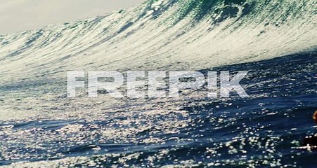 Big wave glistens with intense texture as it crashes on surface of water