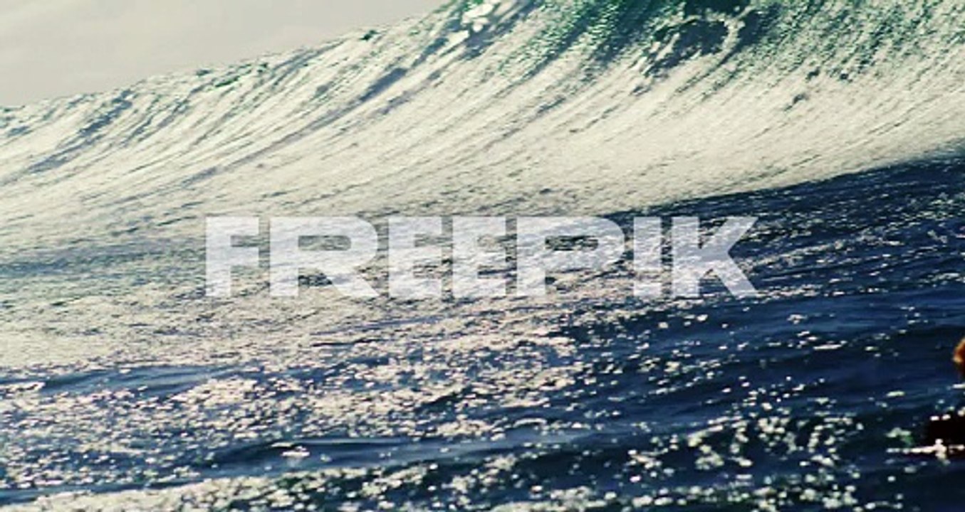 Big wave glistens with intense texture as it crashes on surface of water