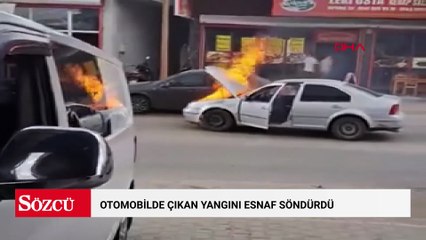 Otomobilde çıkan yangını esnaf söndürdü
