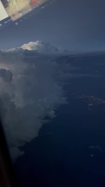 Lightning Illuminates Clouds From Airplane Window