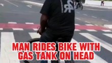 Cyclist With Gas Tank on Head