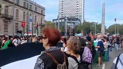 Despliegan una gran bandera antes del inicio de la manifestación por la liberación de los activistas de la Flotilla en Barcelona