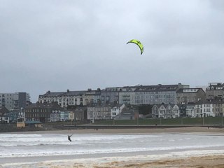 Kitesurfer enjoys the last of Storm Amy on Portrush West Strand Beach