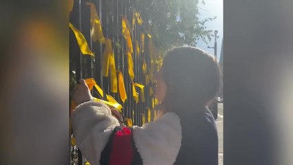 Woman cuts down yellow ribbons commemorating Israeli hostages