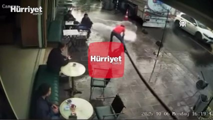 Bir kişinin tazyikli suyla çevredekileri ıslatması kamerada