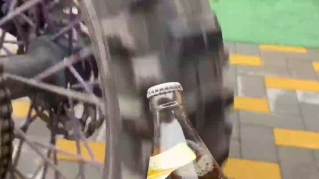 Lad uses enduro motorcycle's spinning wheel to open a bottle