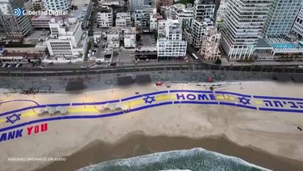 Colocan una gran pancarta con las palabras "gracias" y "hogar" en la playa de Tel Aviv