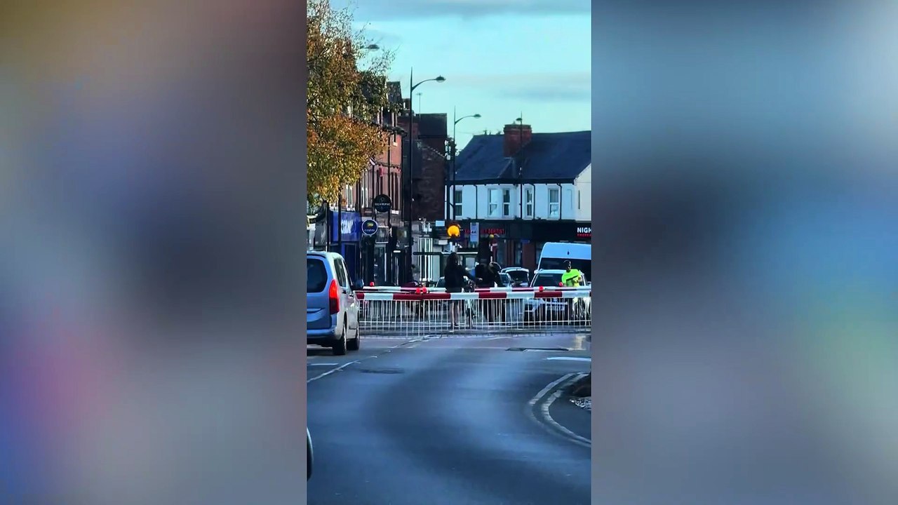 Woman ignores level crossing barriers - carries bike over tracks