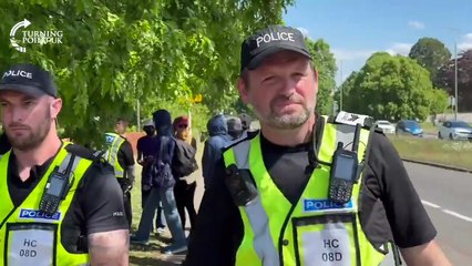 Hampshire Constabulary escort masked ANTIFA thugs past a local-led migrant..