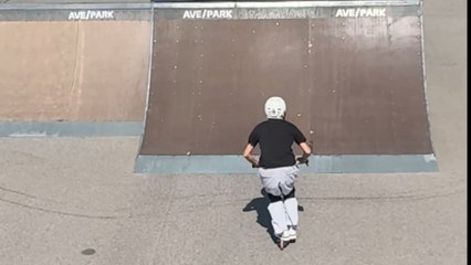 Scooter rider tries a daring backflip during skatepark session but fails and crashes to the ground