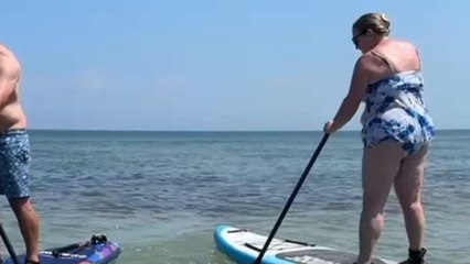 Woman tries paddleboarding but ends up with a funny backward fall into the water