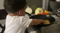 Little boy sees his mom washing dishes and decides to do the same