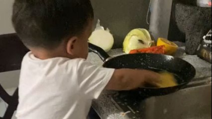 Little boy sees his mom washing dishes and decides to do the same