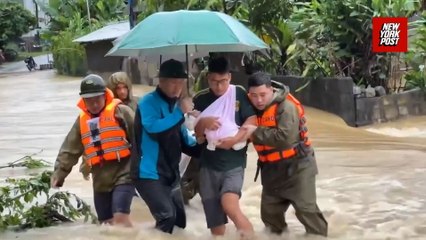 Newborn baby carried through floodwaters as Typhoon batters Vietnam