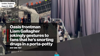 Oasis frontman Liam Gallagher jokingly gestures to fans that he's snorting drugs in a porta-potty