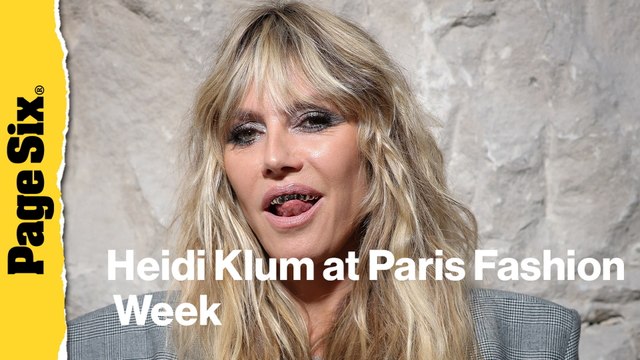 Heidi Klum pairs completely see-through lace dress with a platinum grill at Vetements show during Paris Fashion Week