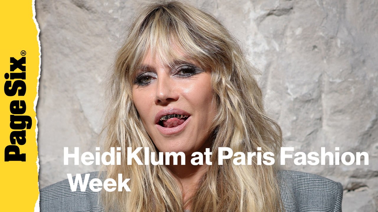 Heidi Klum pairs completely see-through lace dress with a platinum grill at Vetements show during Paris Fashion Week