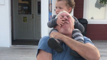 Little boy thinks he will fall and grabs grandpa's lip and hair in panic