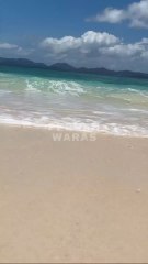 the roar of the waves on the white sand