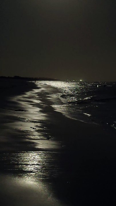 The moon illuminates the sea of Isla Cristina, leaving a golden reflection on the waves.