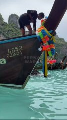 Swimming among wooden boats with clear sea water