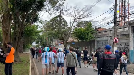 Via de mão dupla! Enquanto algumas pessoas vão em direção a estação de trem, outras sobem a rua para pegar os carros