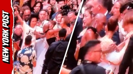 Cynthia Erivo rushes to protect Ariana Grande from a charging fan on the red carpet in Singapore