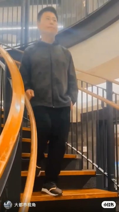 The spiral staircase of The Octagon, a luxury apartment building on Roosevelt Island, has a unique style. Resident Nelson Wang is walking down the stairs. Photographed in the summer and autumn of 2025.
