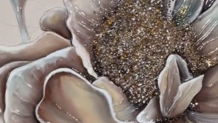 Artist pours a liquid coat over textured flower painting and gives it glossy shin