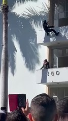 Des agents de sécurité descendent en rappel pour maîtriser un individu sur un balcon.