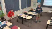 Boy Falls While Trying to Jump Over Multiple Chairs in Class