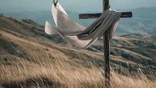 Cross on a hillside with a shawl on it blowing